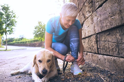 Older woman with dog tying shoe